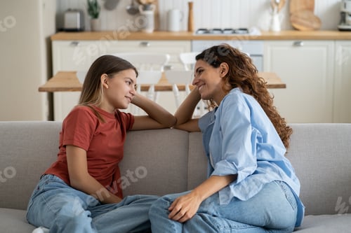 A mother and teenage daughter talking closely