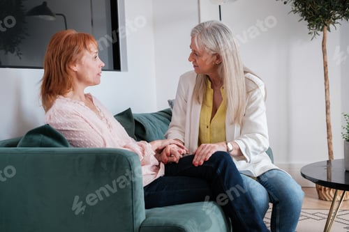 Two women talking supportively on a sofa