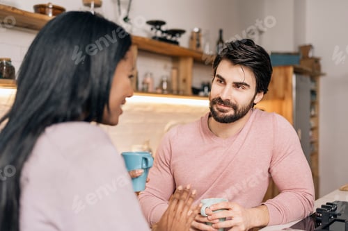 A couple talking over coffee in their kitchen