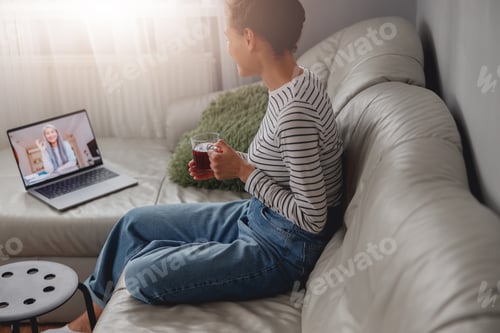 A woman on a relaxed video call with her therapist
